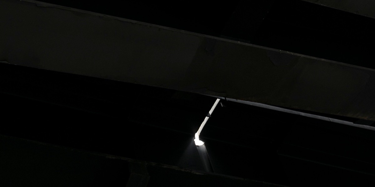A single beam of light breaking through a dark industrial space